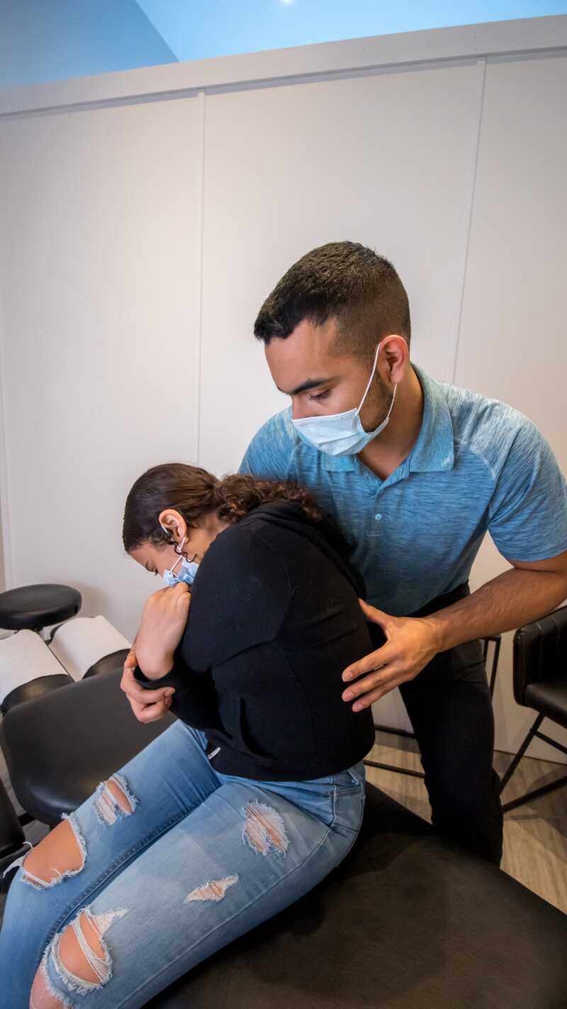 male chiropractor treating young female patient